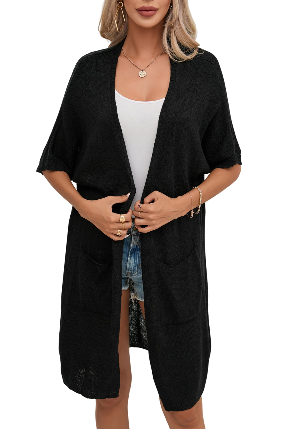 Add some edge to your outfit with our Black Dolman Half Sleeve Pocketed Long Cardigan. This versatile piece brings comfort and style with its half sleeves and convenient pockets. Perfect for any occasion, it's a must-have for your wardrobe!