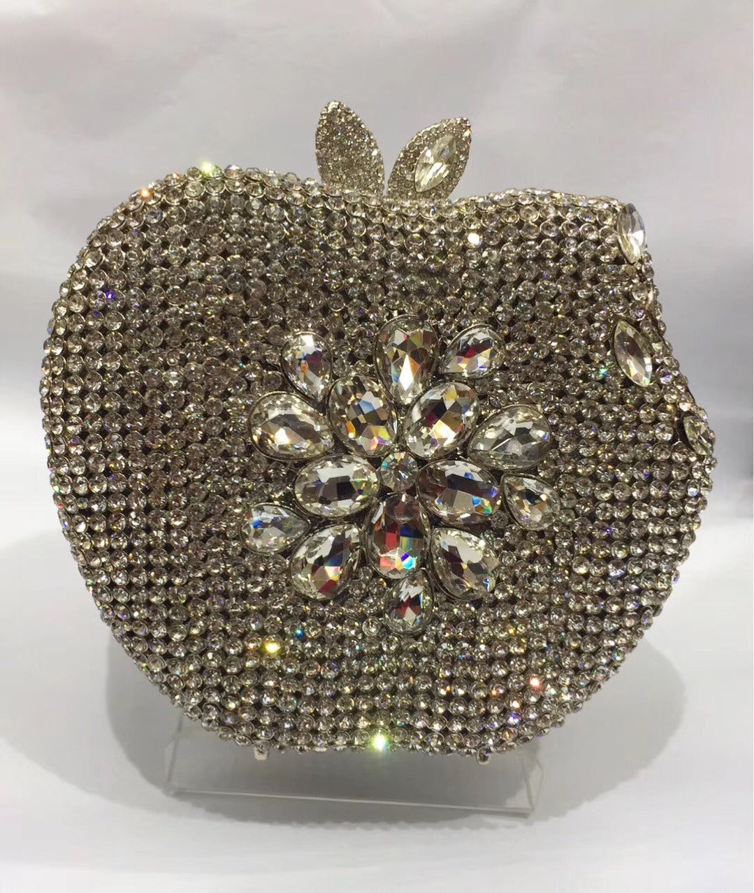 Add a pop of whimsy and style to your outfit with our Rhinestone Apple Shaped Handbag! Available in 8 vibrant colors, this playful clutch features a detailed rhinestone apple design and a convenient chain shoulder strap. Perfect for any fashionista looking to make a statement! (No worms included.)