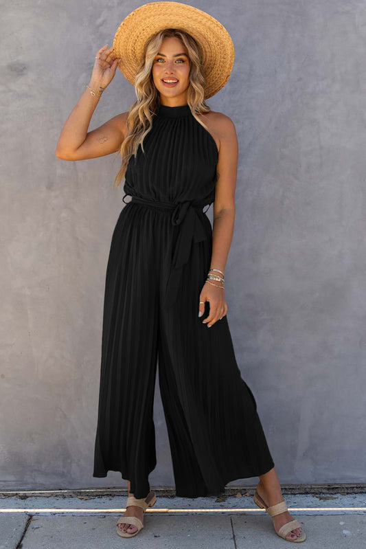 Experience effortless style and sophistication with our One-Piece Black Halter Neck Jumpsuit. The pleated wide leg design elongates your figure while the halter neck adds a touch of elegance. Complete the look with the included belt for a cinched waist. Elevate your wardrobe with this must-have piece!