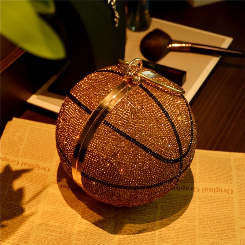 This Rhinestone Studded Basketball Clutch Purse is a stylish and unique accessory that will upgrade any outfit. With its stunning rhinestone studded design, it adds a touch of sparkle and glamour. Perfect for basketball lovers or anyone looking to add a playful twist to their look.