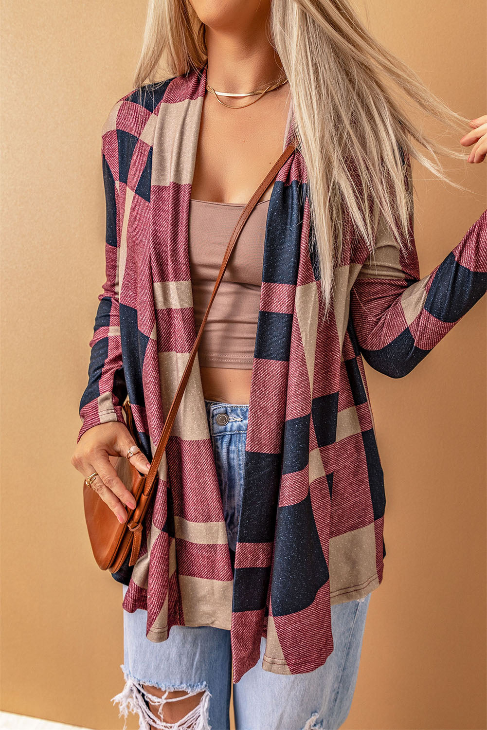 Unleash your inner fashionista with our Draped Open Front Plaid Cardigan. This versatile piece adds a touch of casual chic to any outfit. The draped design creates a relaxed look, while the open front allows for easy styling with a t-shirt, jeans, and sneakers. Made with soft and lightweight fabric for a cozy feel. Unleash your style and comfort with this must-have cardigan.