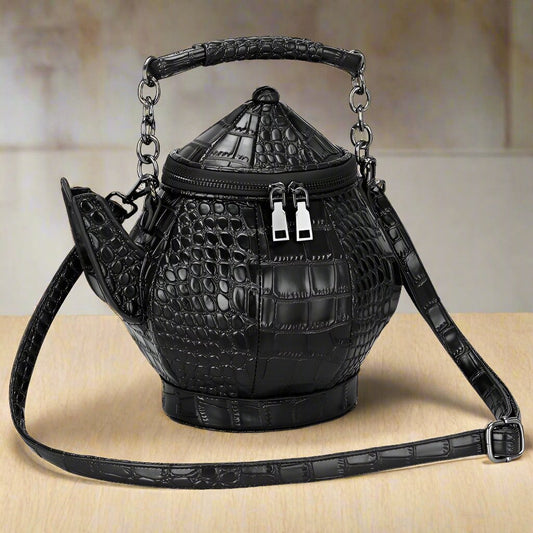 Unleash your unique and stylish side with this Black Leather Tea Pot Handbag. Its faux leather top handle and shoulder strap make it both chic and versatile. Its one-of-a-kind tea pot shape will turn heads and the spacious interior ensures all your essentials are safely stored.