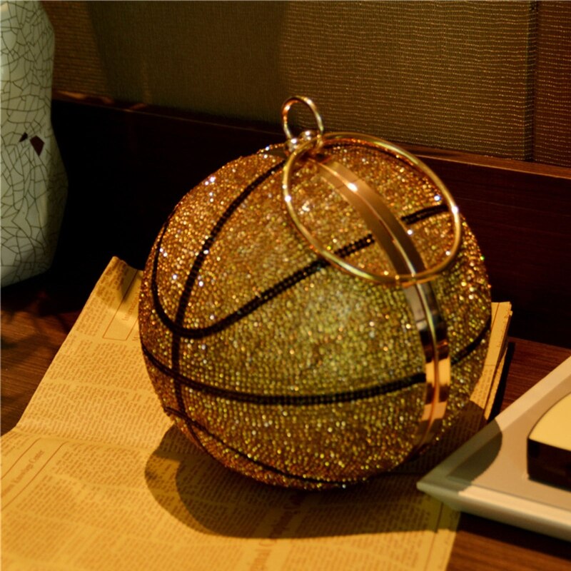 This Rhinestone Studded Basketball Clutch Purse is a stylish and unique accessory that will upgrade any outfit. With its stunning rhinestone studded design, it adds a touch of sparkle and glamour. Perfect for basketball lovers or anyone looking to add a playful twist to their look.