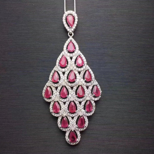 Indulge in the exquisite beauty of nature with our Ruby and Sterling Silver Peacock Tail Feather Pendant Necklace. Adorned with natural rubies and crafted from sterling silver, this necklace showcases the intricate details of a peacock tail feather. A mesmerizing and unique piece that will add a touch of elegance to any outfit.