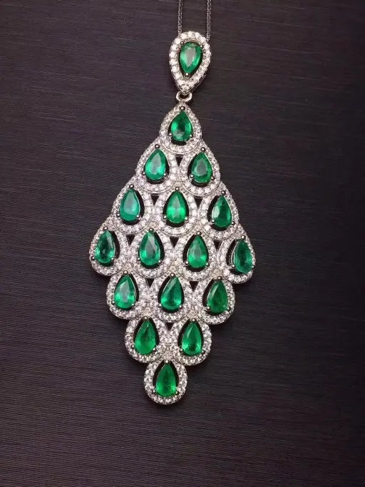 Indulge in the luxurious beauty of our Emerald Zircon Peacock Tail Feather Pendant Sterling Silver Necklace. Crafted with stunning emerald zircon stones and intricate peacock feather details, this necklace is sure to make a statement. Elevate any outfit with this elegant and unique piece of jewelry.