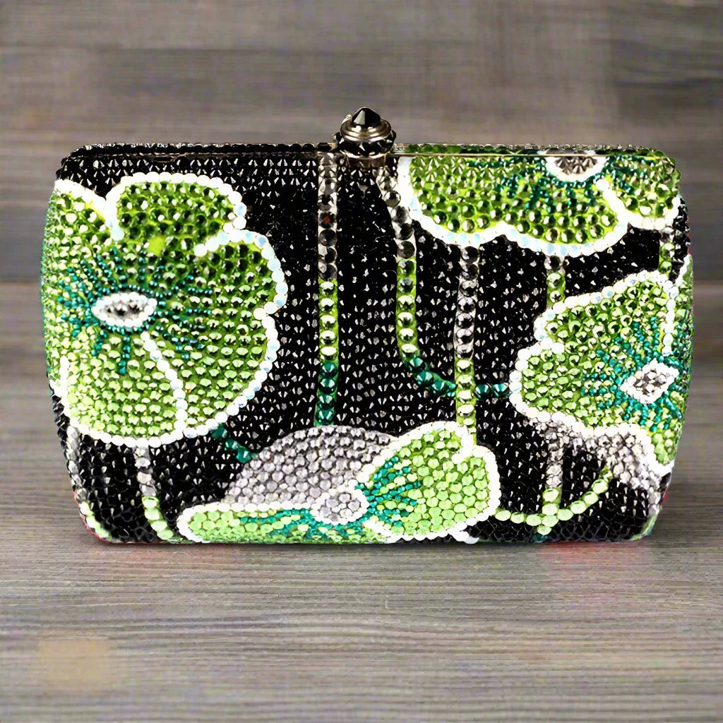 Experience elegance with our Rhinestone Lilly Pad Clutch Handbag. Dazzling rhinestones adorn this chic clutch, making it the perfect accessory for any occasion. Stand out from the crowd and add a touch of glamour to your outfit with this stunning handbag.