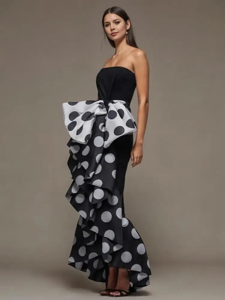 Feel elegant and sophisticated in our stunning black sleeveless evening dress. The polka dot pattern adds a touch of fun, while the bow tie embellishment adds a touch of elegance. Perfect for any special occasion, this dress will make you feel confident and beautiful.