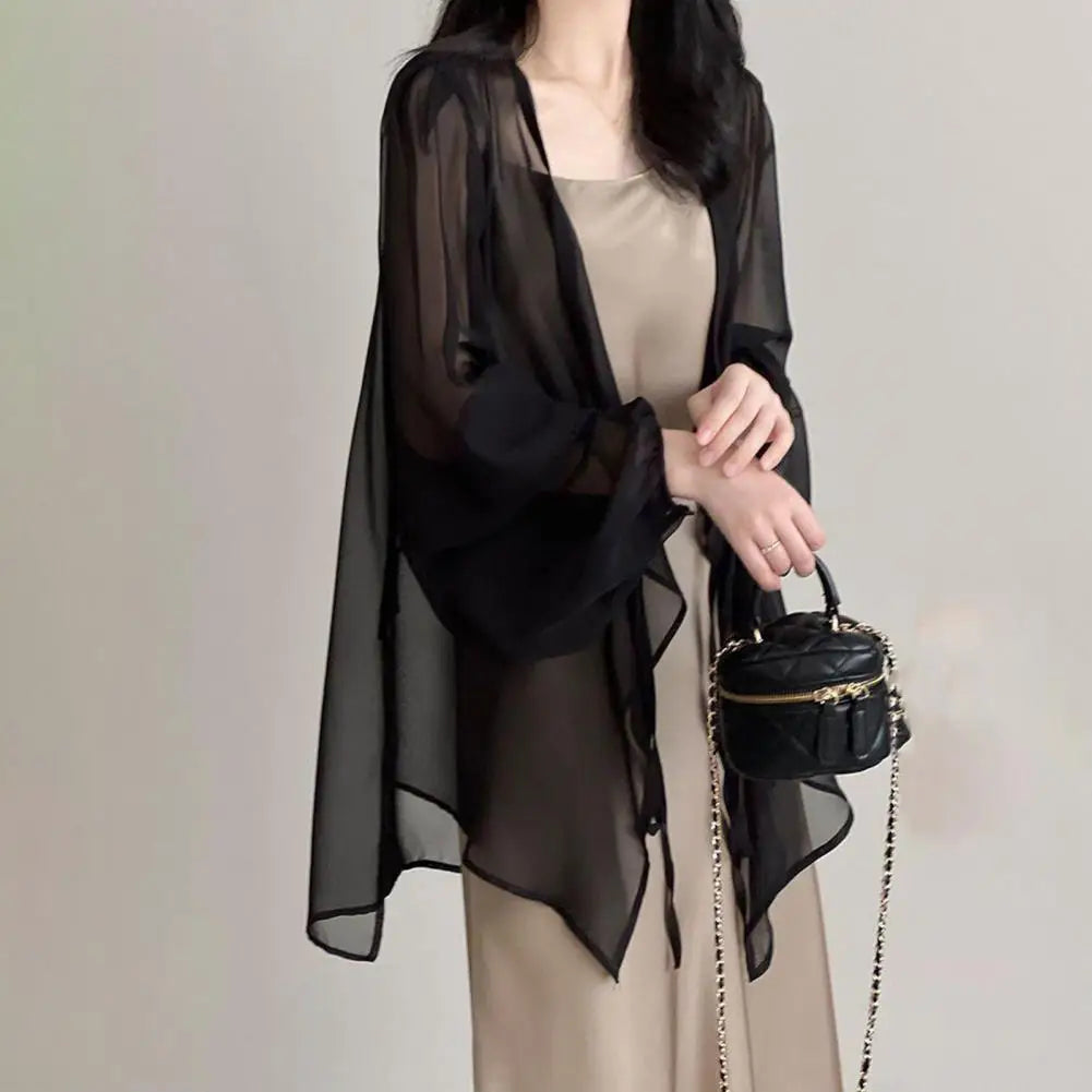 Stay stylish and protected this summer with our Long Sleeve Chiffon Sunscreen Cover Up! Made with lightweight chiffon material, it features a front tie closure for easy adjustability. Available in black, white, and khaki, this cover up is the perfect addition to your summer wardrobe.