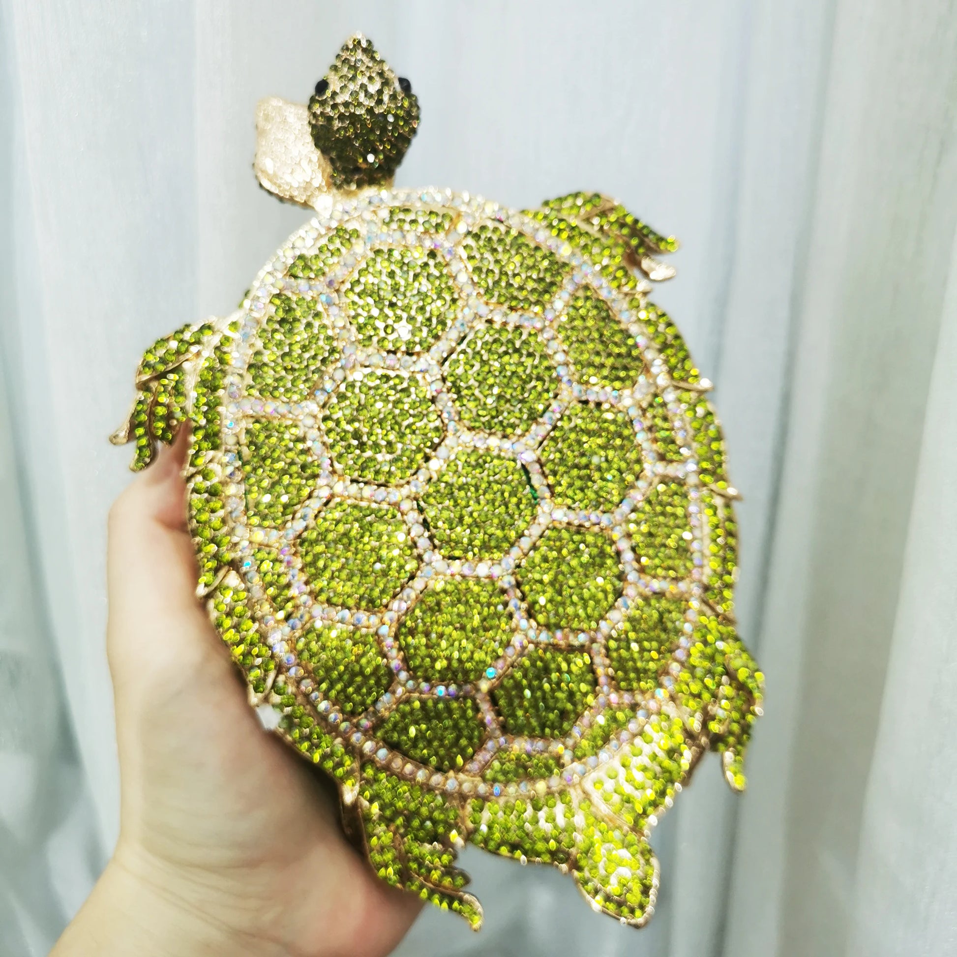 Unleash your wild side with our Rhinestone Turtle Clutch Purse. Adorned with dazzling rhinestones, this novelty bag is a statement piece that will elevate any outfit. Carry your essentials in style and make a bold fashion statement with this unique and stylish clutch purse.