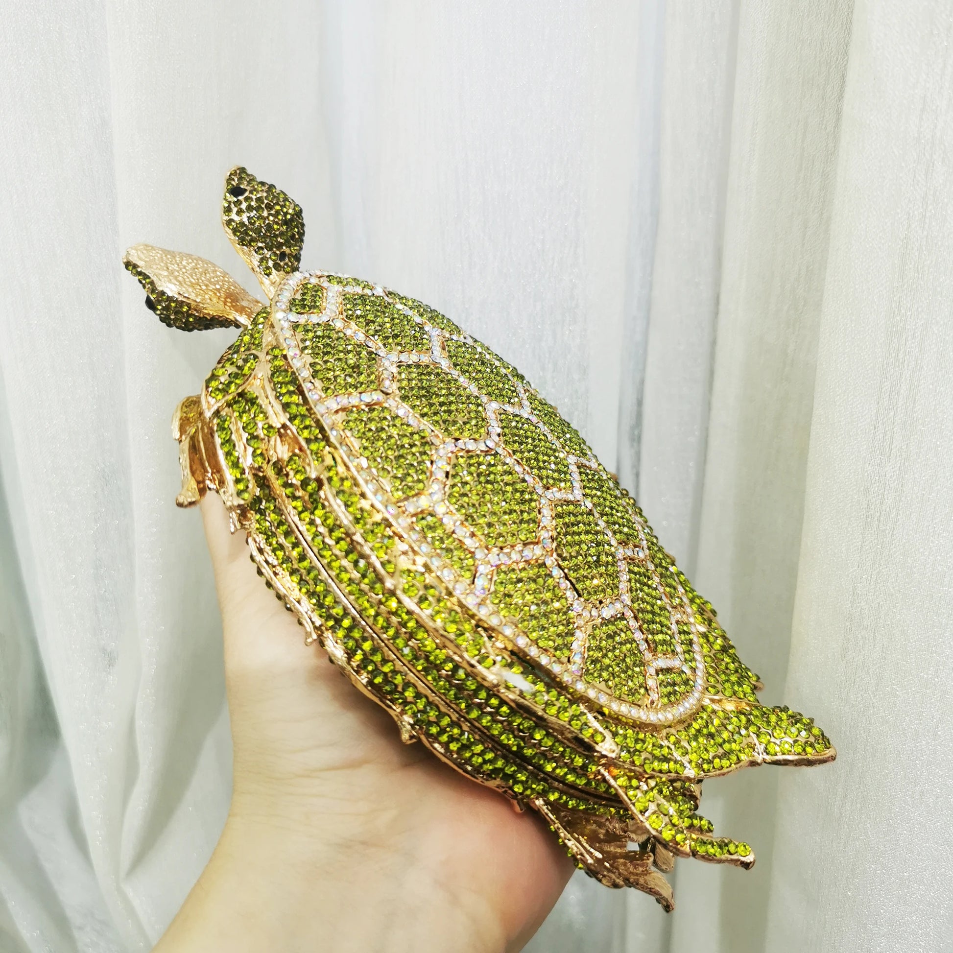 Unleash your wild side with our Rhinestone Turtle Clutch Purse. Adorned with dazzling rhinestones, this novelty bag is a statement piece that will elevate any outfit. Carry your essentials in style and make a bold fashion statement with this unique and stylish clutch purse.