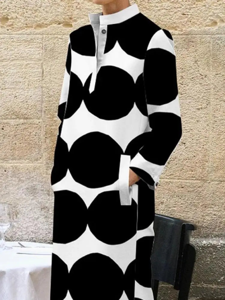 Embrace timeless elegance with our Black &amp; White Maxi Length Coat Dress. With its sleek design and pockets for convenience, this dress is both stylish and functional. Perfect for any occasion, this dress exudes sophistication and class. Elevate your wardrobe with this must-have piece.