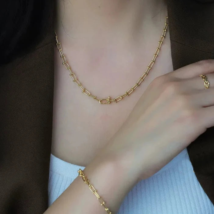 Indulge in the ultimate luxury with our Horseshoe Chain Necklace and Bracelet Set. Made of exquisite 18K gold, this designer jewelry is the perfect accessory for any occasion. Its trendy horseshoe chain design exudes elegance and sophistication, making it a beautiful gift or to elevate any outfit.