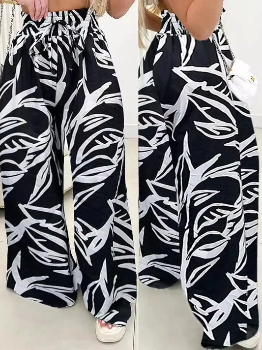 Elevate your style with our Black Wide Leg Pants! The white floral leaf print adds a touch of whimsy, while the elastic high waist guarantees a comfortable fit. Perfect for a day at the office or a night out, these pants from Thread Harbor Clothing Company are a must-have for any fashion-forward individual.