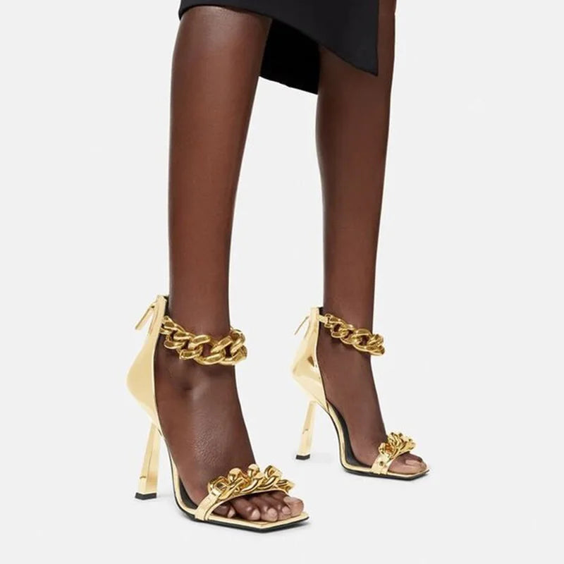 Elevate your style with our Gold Chain Wedge Stiletto Sandal. The sleek design features a buckle strap for a secure fit and a wedge heel adorned with a luxurious gold chain. Make a statement with every step in these exclusive sandals.