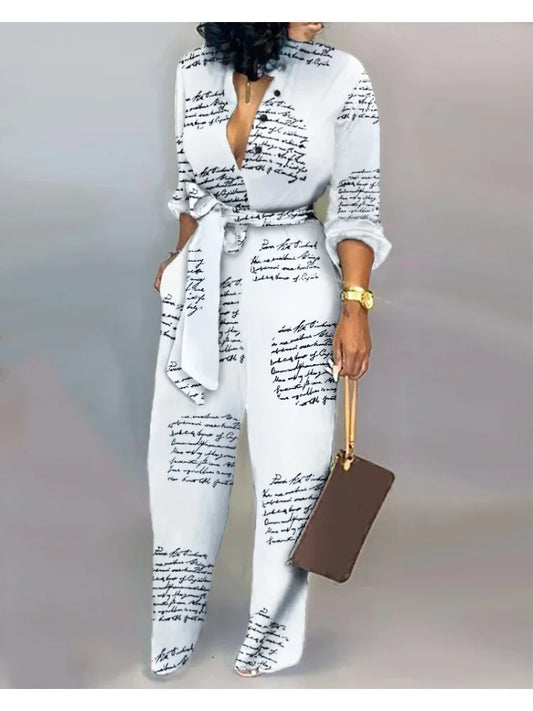 Elevate your style with our White Jumpsuit from Thread Harbor Clothing Company. Crafted from a comfortable blend of cotton and linen, this jumpsuit features a bold black text print, long sleeves, and a flattering sash waist tie. The v-neck and button front add a touch of sophistication. Make a statement in our modern and chic jumpsuit!