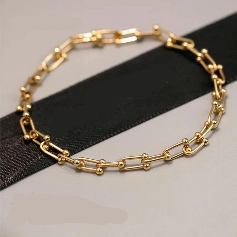 Indulge in the ultimate luxury with our Horseshoe Chain Necklace and Bracelet Set. Made of exquisite 18K gold, this designer jewelry is the perfect accessory for any occasion. Its trendy horseshoe chain design exudes elegance and sophistication, making it a beautiful gift or to elevate any outfit.