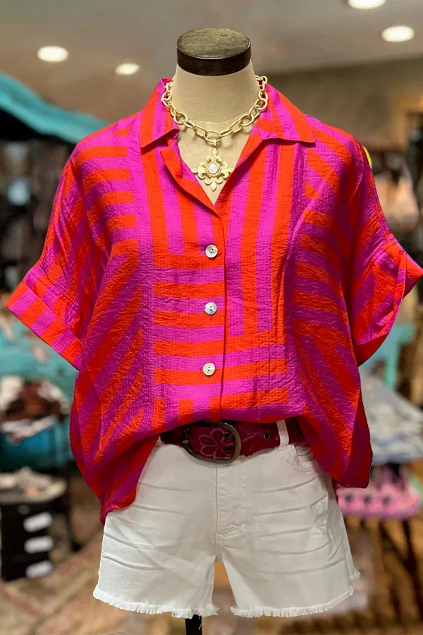 Transform your wardrobe with our Button Down Cotton Blouse! Made from high-quality cotton, this blouse features a trendy turn down collar and short sleeves for a chic look. The vibrant tribal print in bright pink, orange, and purple stripes adds a pop of color to any outfit. With its button down design and unique slit back, this blouse is both stylish and functional. Upgrade your style game today!