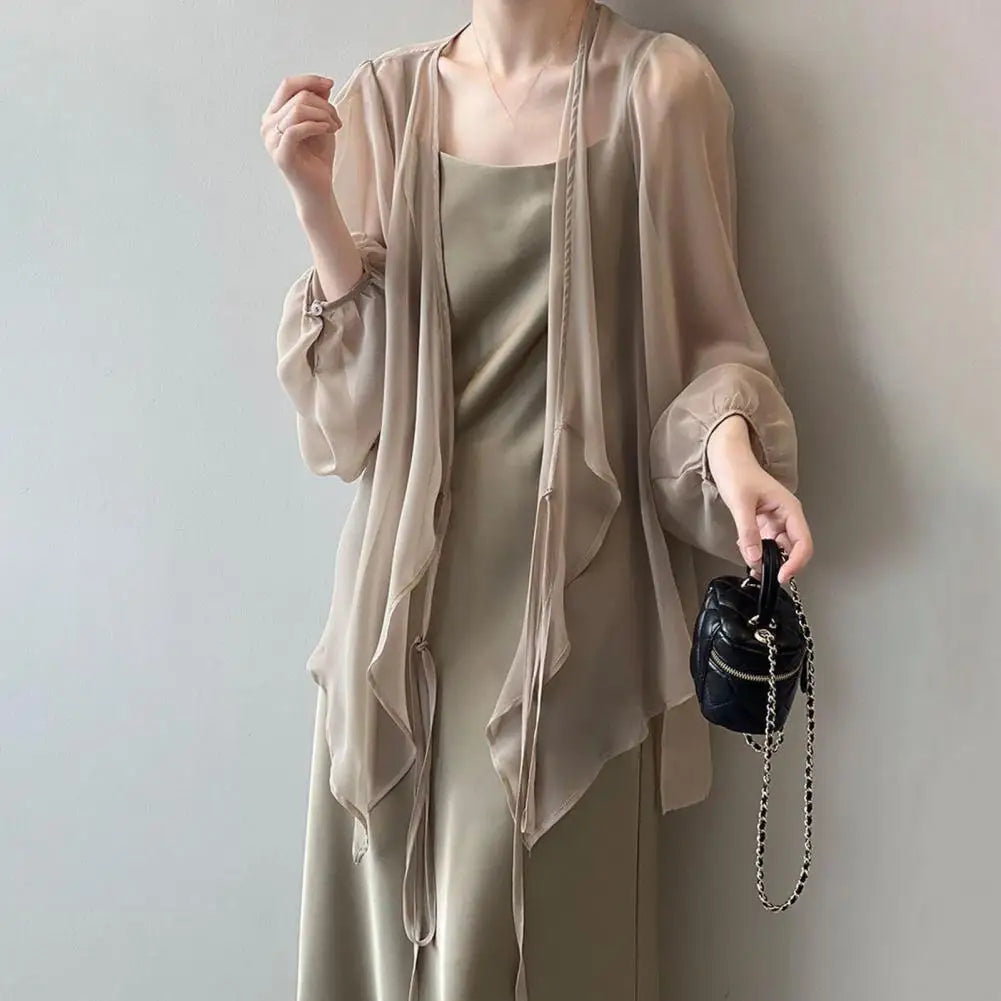 Stay stylish and protected this summer with our Long Sleeve Chiffon Sunscreen Cover Up! Made with lightweight chiffon material, it features a front tie closure for easy adjustability. Available in black, white, and khaki, this cover up is the perfect addition to your summer wardrobe.