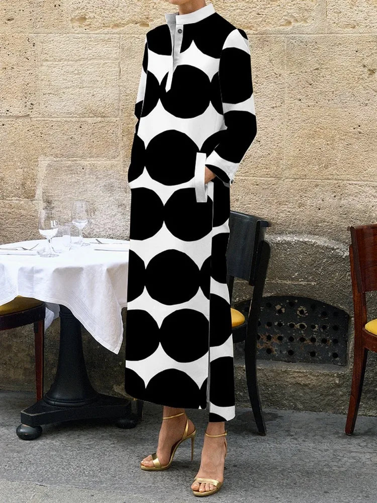 Embrace timeless elegance with our Black &amp; White Maxi Length Coat Dress. With its sleek design and pockets for convenience, this dress is both stylish and functional. Perfect for any occasion, this dress exudes sophistication and class. Elevate your wardrobe with this must-have piece.