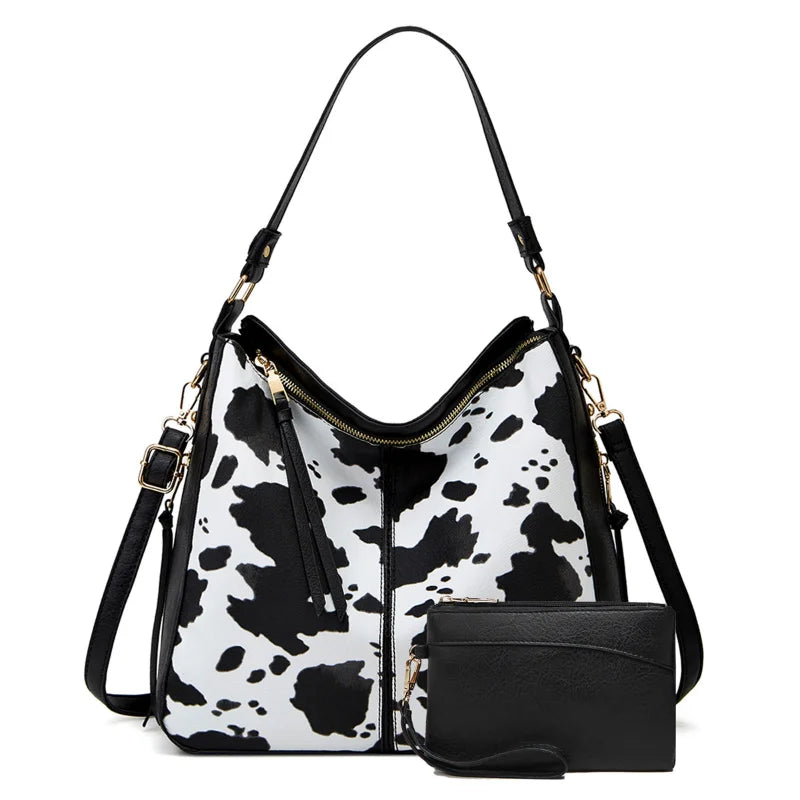 Front of black and white faux cowhide bag with matching black wallet and black shoulder strap.  Stay stylish and organized with our Large Capacity Leopard/Cow Print Shoulder Bag. Includes a matching wallet for added convenience. Perfect for on-the-go fashionistas!