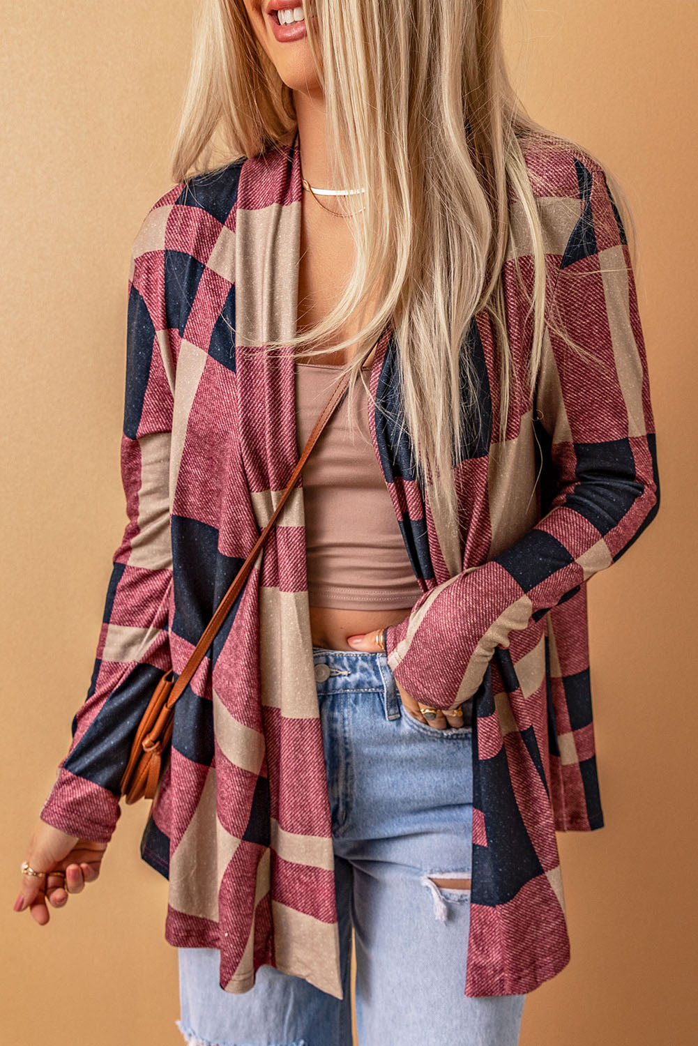 Unleash your inner fashionista with our Draped Open Front Plaid Cardigan. This versatile piece adds a touch of casual chic to any outfit. The draped design creates a relaxed look, while the open front allows for easy styling with a t-shirt, jeans, and sneakers. Made with soft and lightweight fabric for a cozy feel. Unleash your style and comfort with this must-have cardigan.