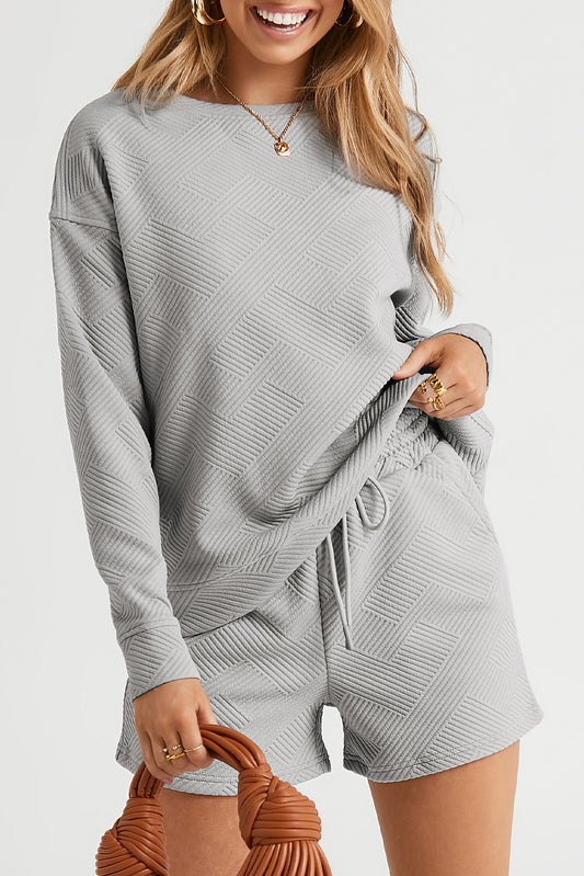 Elevate your loungewear with our Gray Textured Set. Stay cozy and chic with the textured design, long sleeves for warmth, and adjustable drawstring shorts. Perfect for any occasion, make this set your go-to for comfort and style.