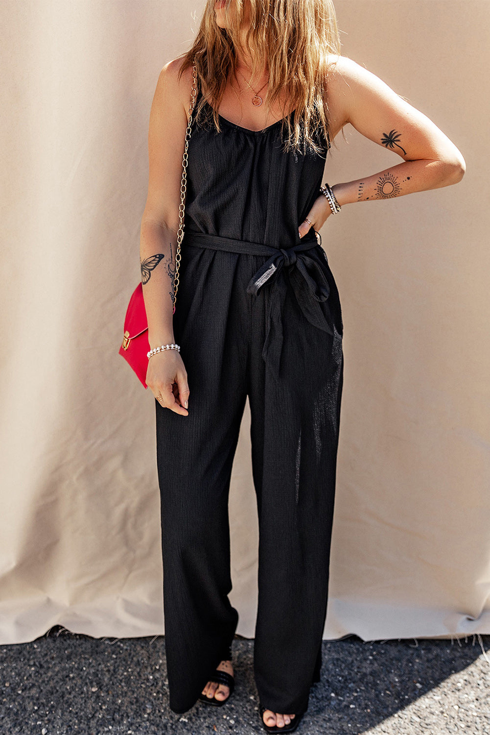 Elevate your style with our Black Textured Belted Wide Leg Sleeveless Jumpsuit. This elegant piece is designed to offer comfort and versatility, with its wide leg design and sleeveless top. The textured fabric and belted waist add a touch of sophistication, making it perfect for any occasion. Step out in style and turn heads wherever you go!