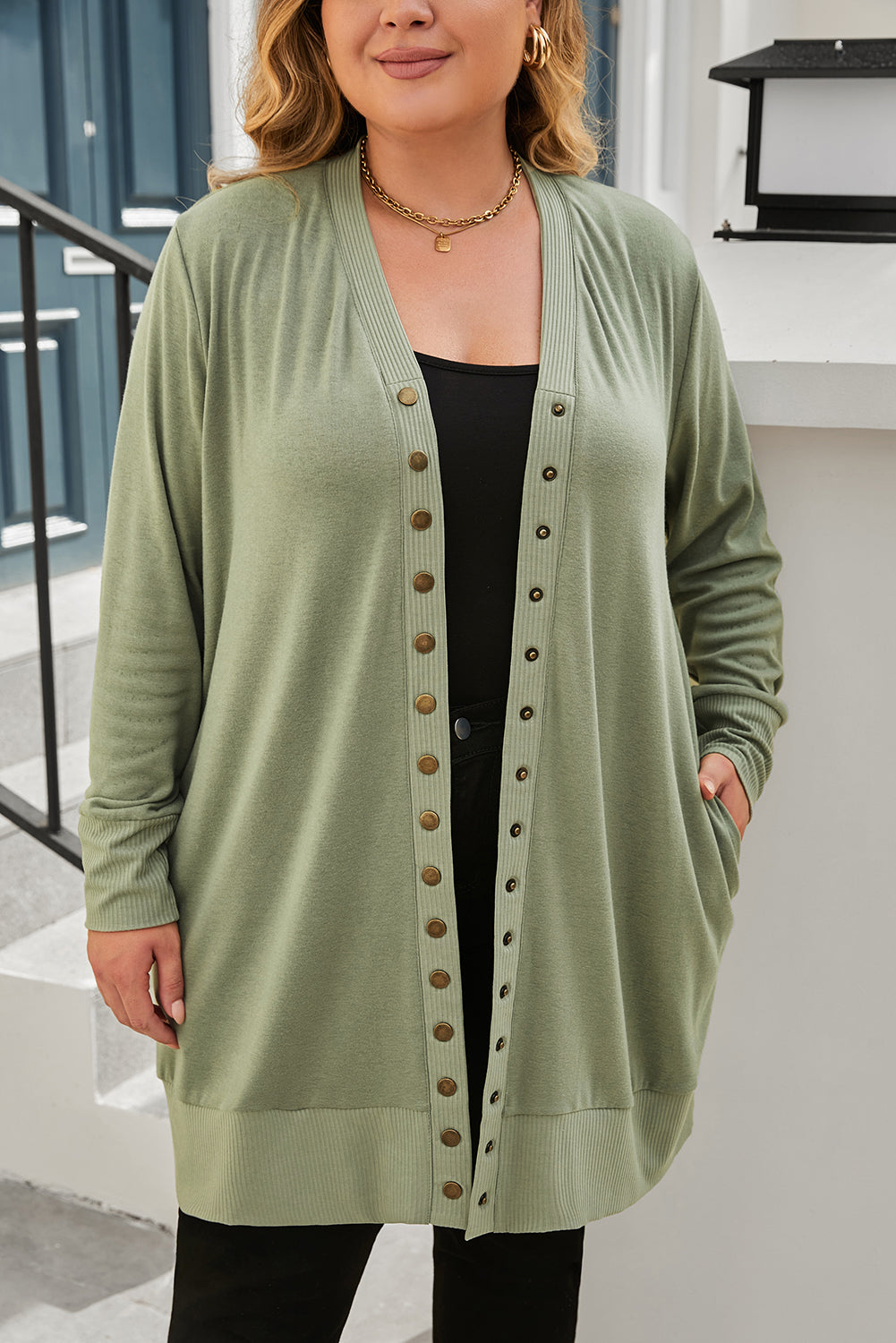 A versatile and dainty addition to any wardrobe, this green plus-size cardigan features a snap-button closure and ribbed trim for a vintage feel. With convenient pockets, it's perfect for adding a touch of warmth while running errands or lounging at home. Pair with a long-sleeve top and skinny pants for a complete casual look. (Fits ladies of all sizes!)