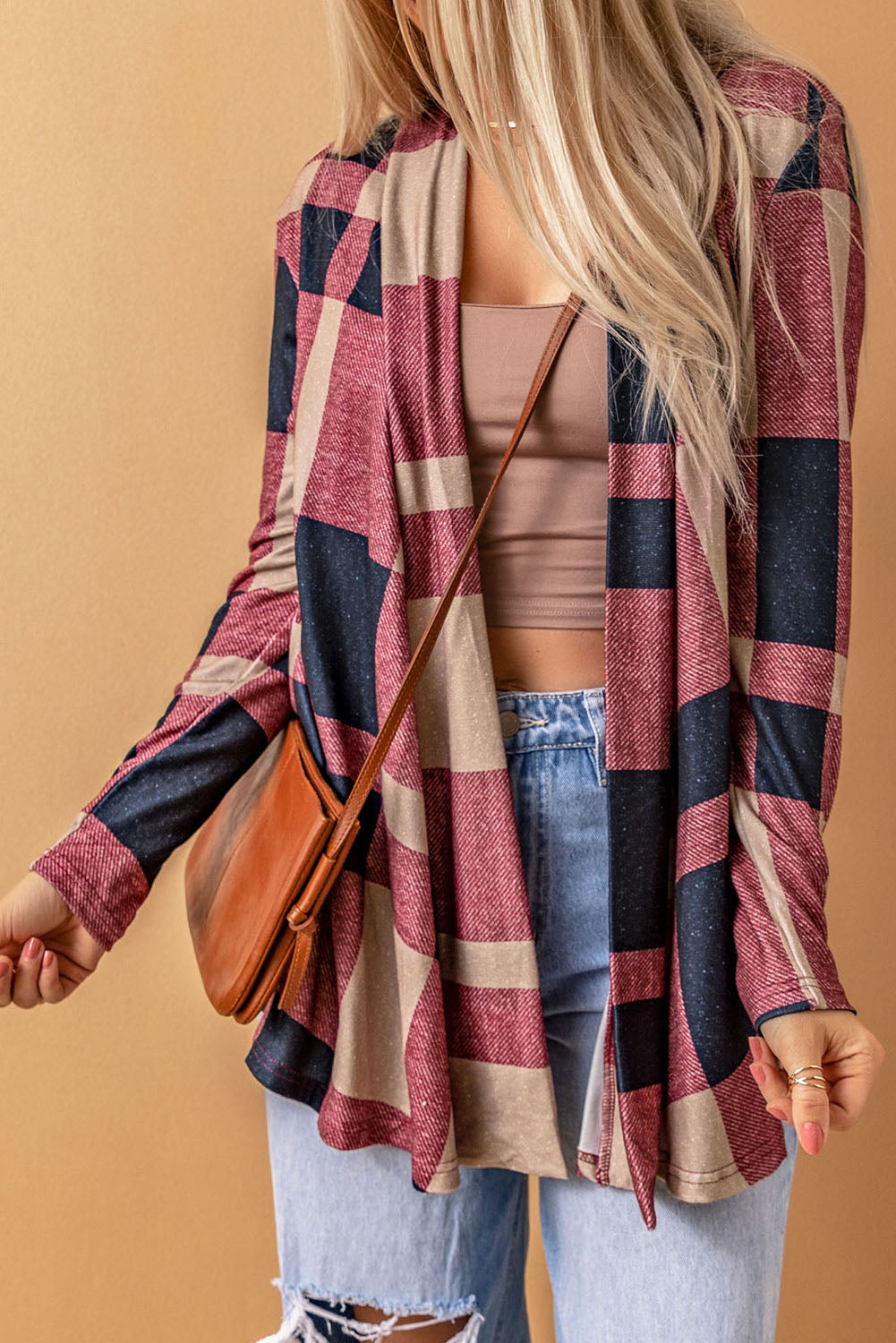 Unleash your inner fashionista with our Draped Open Front Plaid Cardigan. This versatile piece adds a touch of casual chic to any outfit. The draped design creates a relaxed look, while the open front allows for easy styling with a t-shirt, jeans, and sneakers. Made with soft and lightweight fabric for a cozy feel. Unleash your style and comfort with this must-have cardigan.