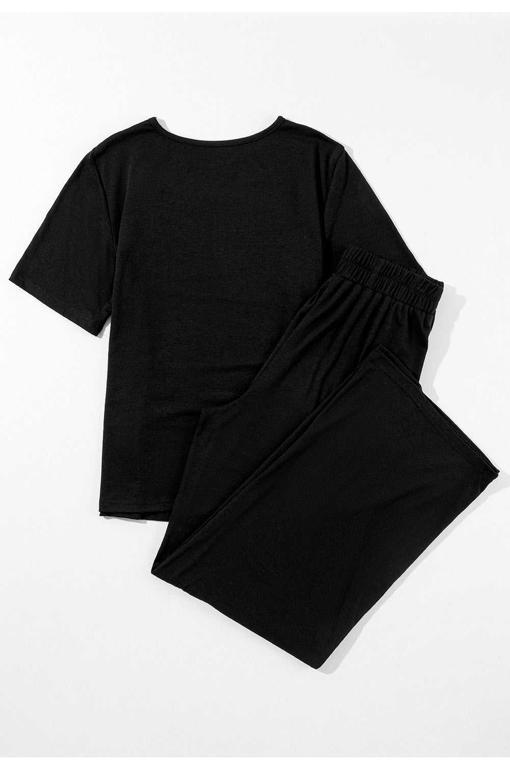 Elevate your wardrobe with our Black Two-Piece Solid Color T Shirt and Wide Leg Pants Set! This stylish set features a flattering black color and comfortable design. Perfect for any occasion, this set will make you look and feel your best. Upgrade your fashion game now!